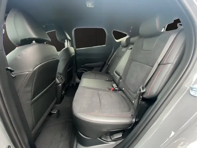 Vue intérieure côté droit des sièges arrière en cuir noir avec surpiqûres rouges du Hyundai Tucson 1.6 Hybrid 2026 gris foncé.