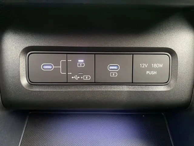 Vue rapprochée des ports USB-C et prise 12V 180W du tableau de bord du Hyundai Tucson gris foncé 2026.