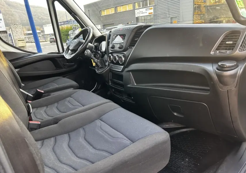 Intérieur de l'IVECO Daily 2020 vu côté passager, montrant la banquette noire et le tableau de bord fonctionnel.