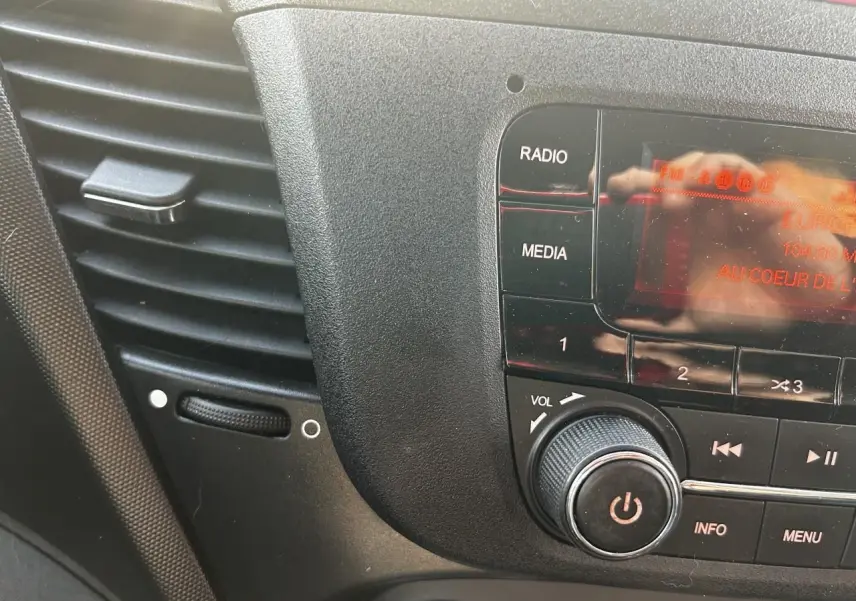 Gros plan sur la console centrale noire de l'IVECO Daily 2020, montrant les commandes radio et volume.