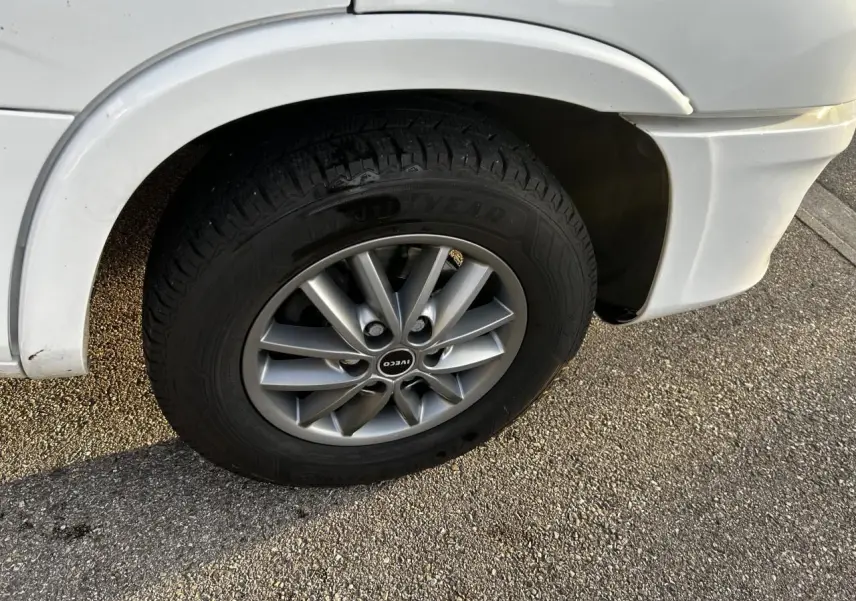 Gros plan sur la roue avant gauche blanche d’un Iveco Daily 2020 avec jante alliage et pneu Goodyear.