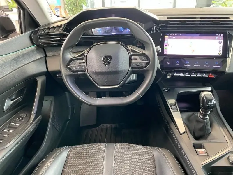 Vue intérieure frontale du poste de conduite gris avec volant compact et écran tactile de la Peugeot 308 2022 diesel.