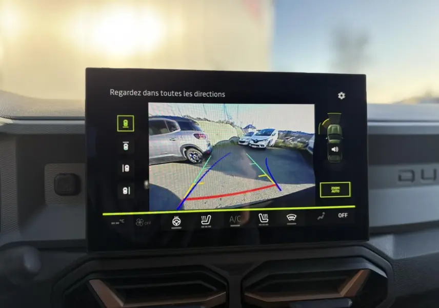 Écran tactile intérieur montrant la caméra 360° du Dacia Duster noir nacré, tableau de bord avec détails brun cuivré.