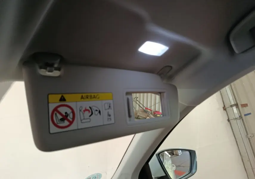 Miroir de courtoisie sur pare-soleil côté conducteur d’un Skoda Karoq blanc, intérieur clair avec rétroviseur visible.