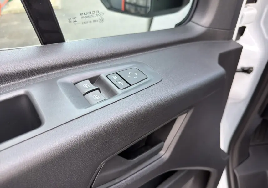 Gros plan sur la porte avant gauche du Renault Master blanc 2026, avec commandes électriques des vitres et réglage des rétroviseurs.