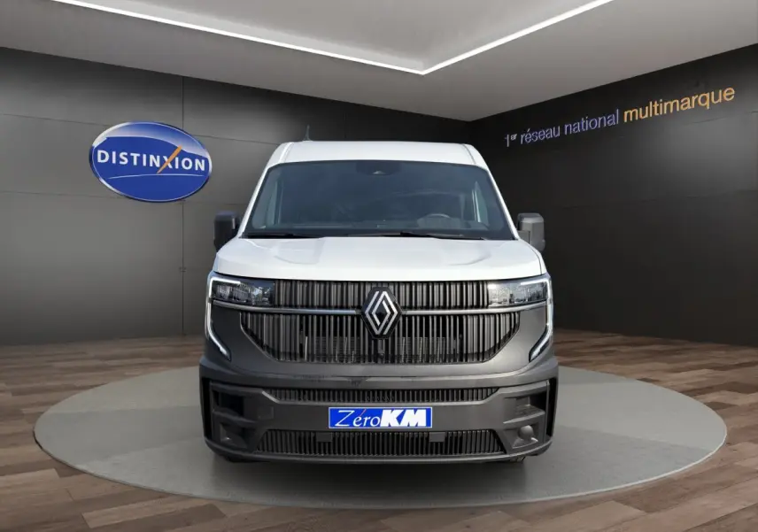 Vue avant d'un utilitaire Renault Master blanc avec calandre noire et logo Renault centré, en showroom.