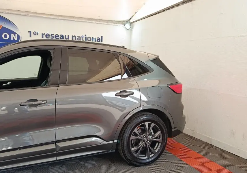 Vue côté droit arrière du Ford Kuga gris foncé 2023, avec jantes alliage et feux arrière LED visibles.