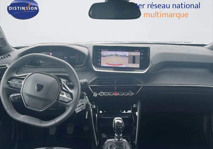 Vue intérieure avant du Peugeot 2008 blanc, mettant en valeur le tableau de bord numérique et l'écran tactile avec caméra de recul.