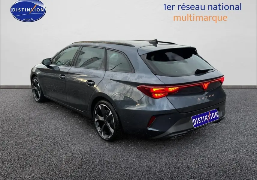 Vue 3/4 arrière droite d'une CUPRA Leon ST gris magnétique avec feux arrière LED allumés et jantes alu noires.