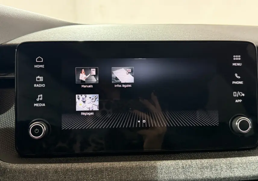Écran tactile central du tableau de bord du Skoda Kamiq 2024 affichant les menus Réglages, Manuels et Infos légales.