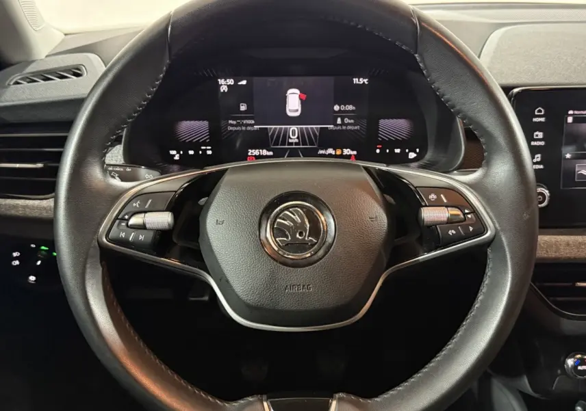 Volant cuir noir SKODA KAMIQ 2024 avec commandes multifonctions et tableau de bord numérique en arrière-plan