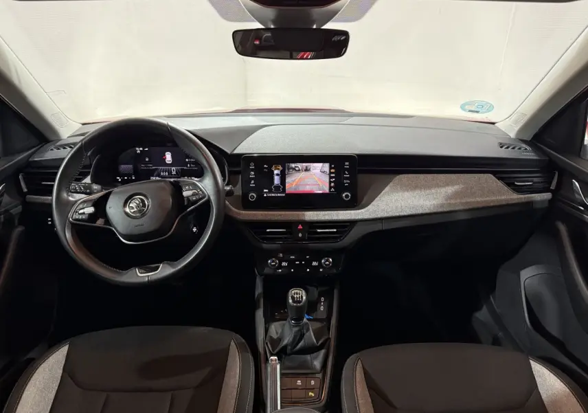 Intérieur de la Skoda Kamiq 2024, vue frontale du tableau de bord avec volant cuir et écran tactile central.