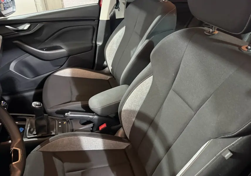 Vue intérieure côté gauche des sièges avant gris et noirs du Skoda Kamiq 2024 avec levier de vitesses manuel visible.
