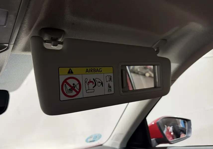 Miroir de courtoisie sur pare-soleil côté conducteur, avec rétroviseur extérieur rouge visible d'un Skoda Kamiq 2024.