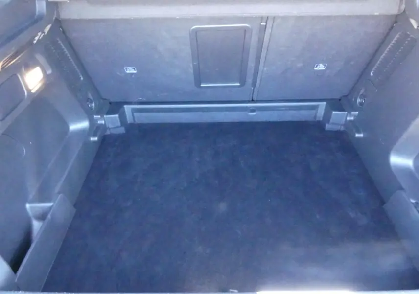 Coffre vide vu de face de l’Opel Grandland blanc métallisé avec intérieur noir et éclairage latéral.