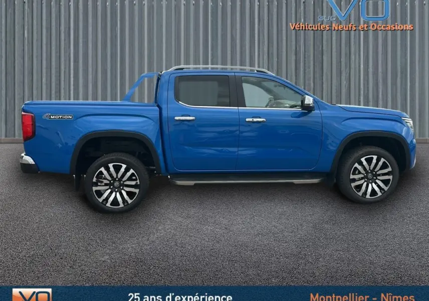 Vue de profil côté gauche d’un Volkswagen Amarok Simple Cabine bleu avec jantes alliage 21 pouces et marchepieds visibles.