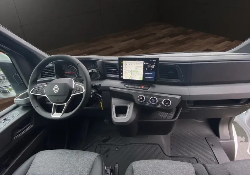 Vue intérieure du tableau de bord du Renault Master blanc 2025, avec écran tactile central et volant multifonction.