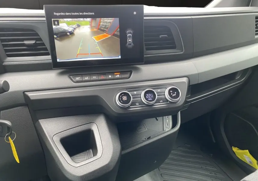 Vue intérieure du tableau de bord du Renault Master blanc 2025, avec écran tactile et commandes de climatisation visibles.