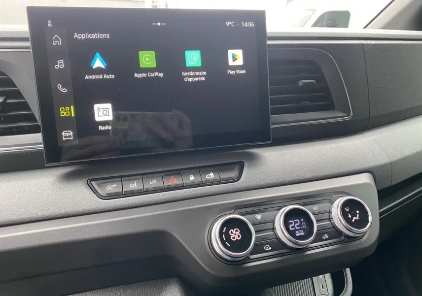 Vue rapprochée de la console centrale du Renault Master blanc, avec écran tactile et commandes de climatisation digitales.