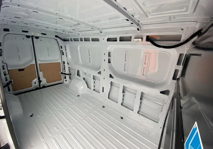 Vue intérieure de la zone de chargement blanche du Renault Master 2025, montrant les parois et plancher tôlés.