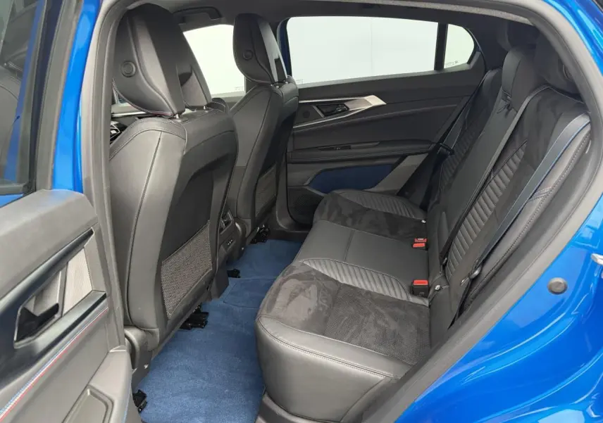 Vue côté gauche de l'intérieur arrière du Renault Rafale Summit Blue avec sellerie noire et tapis bleu.