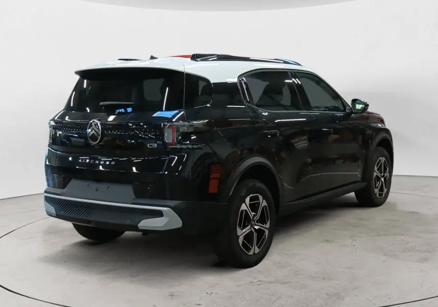 Vue 3/4 arrière droite du Citroën C3 Aircross 2025 noir Perla avec toit blanc, jantes bi-ton et feux LED distinctifs.