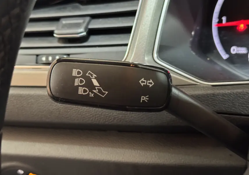 Gros plan sur la commande de clignotants et feux du Volkswagen T-Roc 2021, intérieur gris foncé.