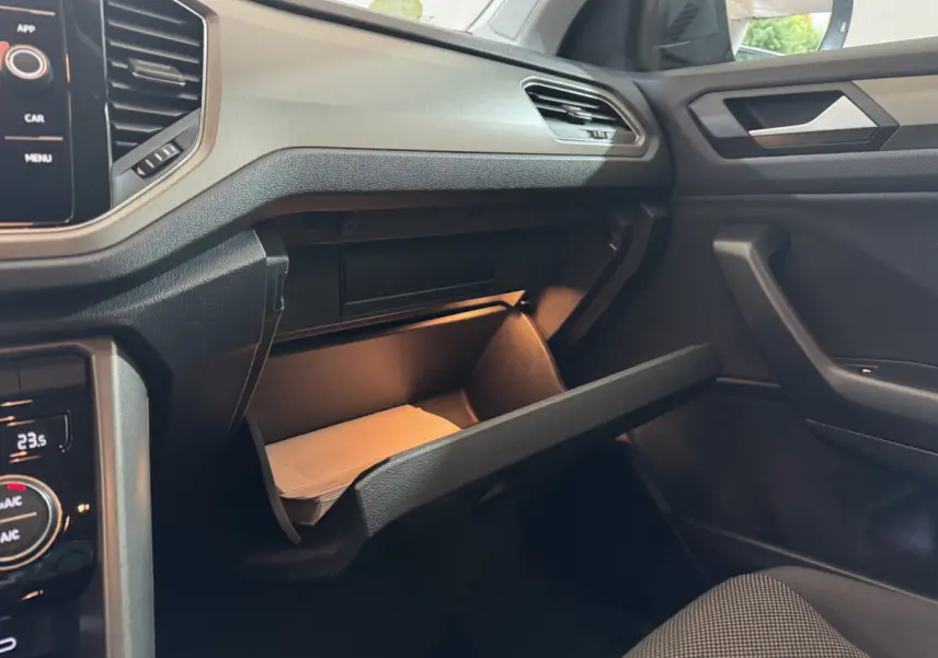Vue intérieure côté passager du Volkswagen T-Roc 2.0 TDI 115 Lounge Business 2021, boîte manuelle, avec boîte à gants ouverte et éclairage intérieur.