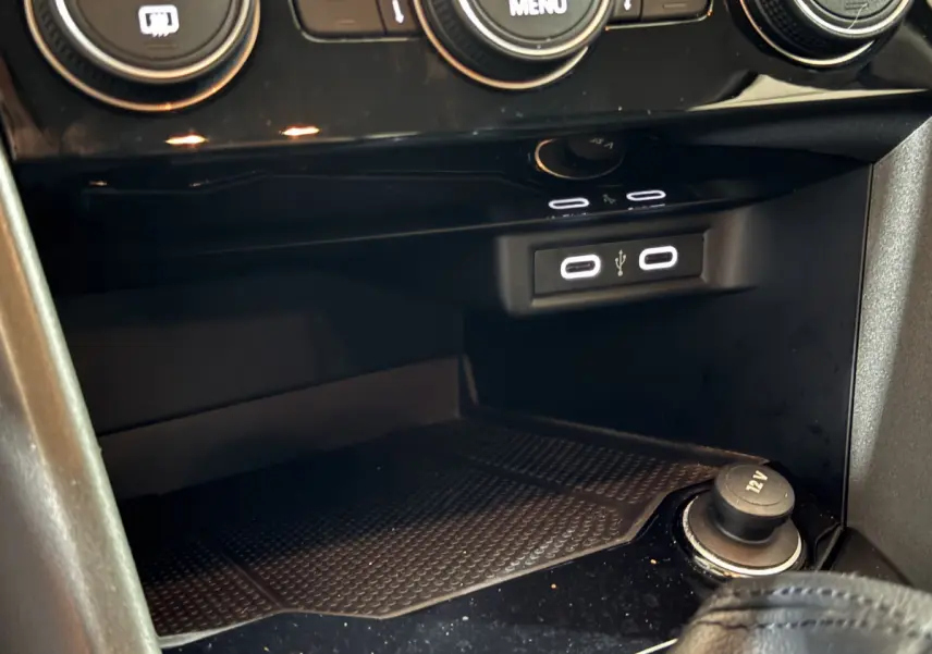 Prise USB double et prise 12V dans la console centrale du Volkswagen T-Roc gris foncé, vue rapprochée intérieure.