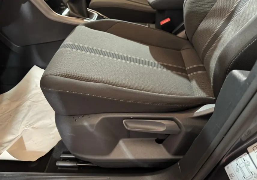 Gros plan sur le siège conducteur gris foncé du Volkswagen T-Roc 2021, version 2.0 TDI Lounge Business, avec réglage manuel.