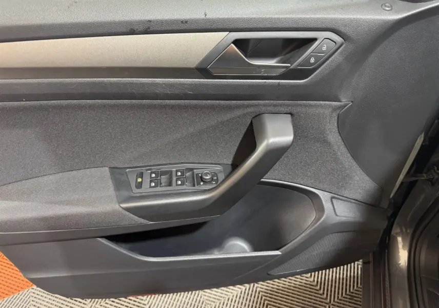 Vue intérieure côté gauche de la porte d’un Volkswagen T-Roc gris foncé avec commandes de vitres et verrouillage.