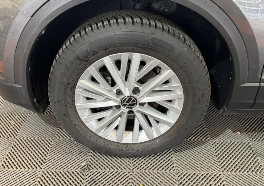 Gros plan sur la roue avant gauche grise du Volkswagen T-Roc 2.0 TDI 115 Lounge Business avec jante en alliage argentée.