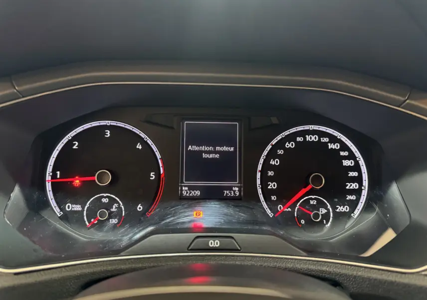 Tableau de bord du Volkswagen T-Roc gris foncé 2021, affichage digital avec message d'alerte moteur et compteurs analogiques.