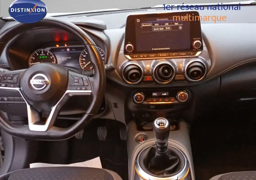 Intérieur du Nissan Juke 2020 gris platine, vue de face sur le tableau de bord avec écran tactile et levier de vitesse manuel.