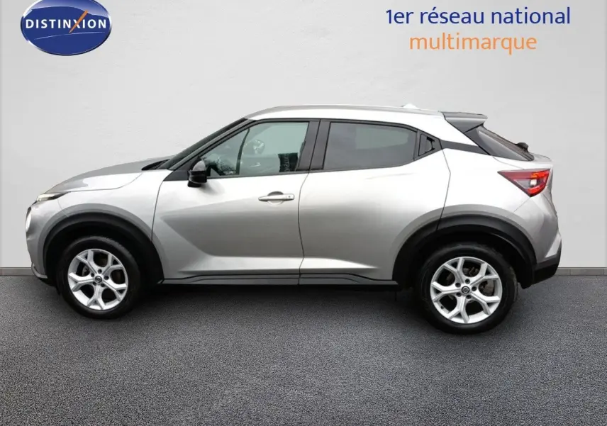 Vue de profil côté gauche d'un Nissan Juke gris platine métal, SUV compact avec jantes alliage 17 pouces.