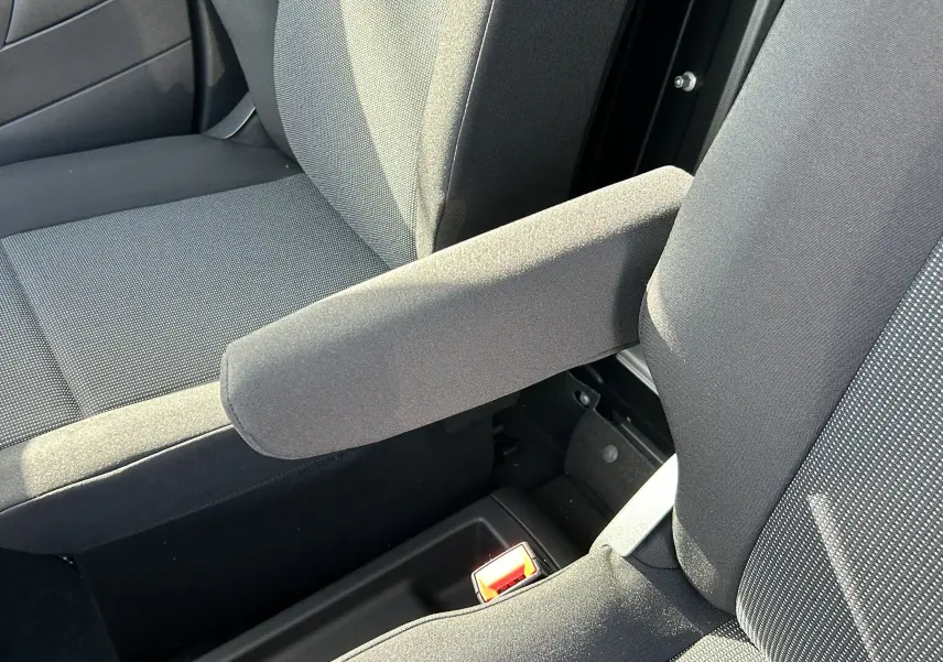 Gros plan sur l'accoudoir central et les sièges en tissu gris foncé de l'intérieur du DANGEL Peugeot Partner 4x4.