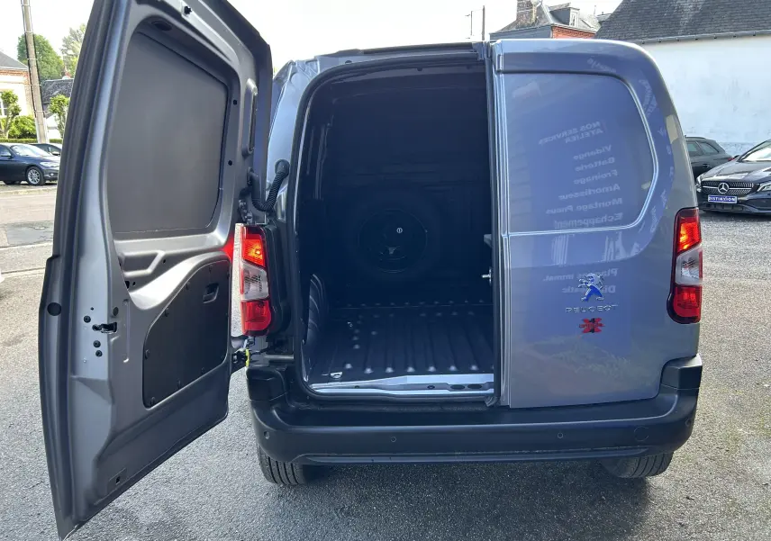 Vue arrière du Peugeot Partner Dangel gris Artense avec porte gauche ouverte montrant l'espace de chargement vide.