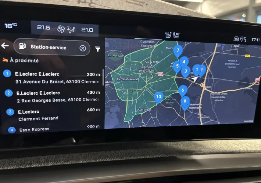 Vue intérieure de l’écran tactile du Peugeot 3008 gris Artense affichant la navigation avec stations-service à proximité.