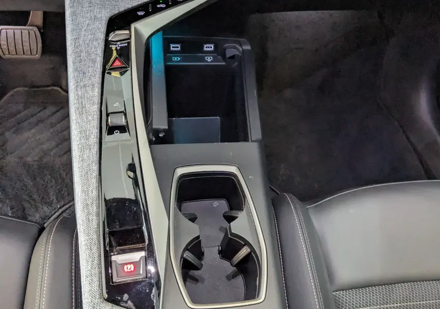 Vue plongeante sur la console centrale du Peugeot 3008 gris 2024, avec porte-gobelets et commandes tactiles.