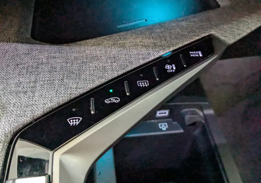 Gros plan sur la console centrale du Peugeot 3008 gris 2024, montrant les commandes tactiles de climatisation et ventilation.