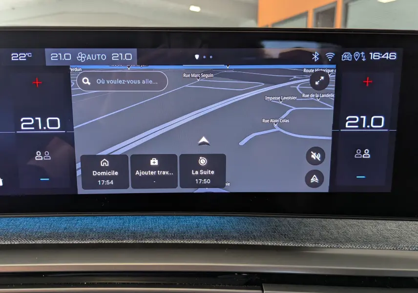Écran tactile central du tableau de bord du Peugeot 3008 gris, affichant la navigation GPS et la climatisation à 21°C.