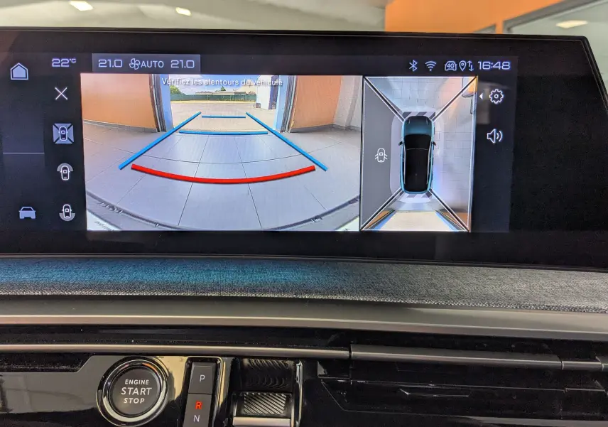 Écran multimédia montrant la caméra de recul et la vue 360° du Peugeot 3008 gris, version hybride 2024.