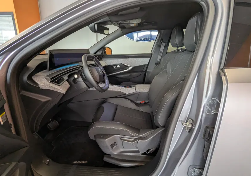 Intérieur côté conducteur du Peugeot 3008 gris 2024, avec sièges noirs, tableau de bord moderne et écran tactile.
