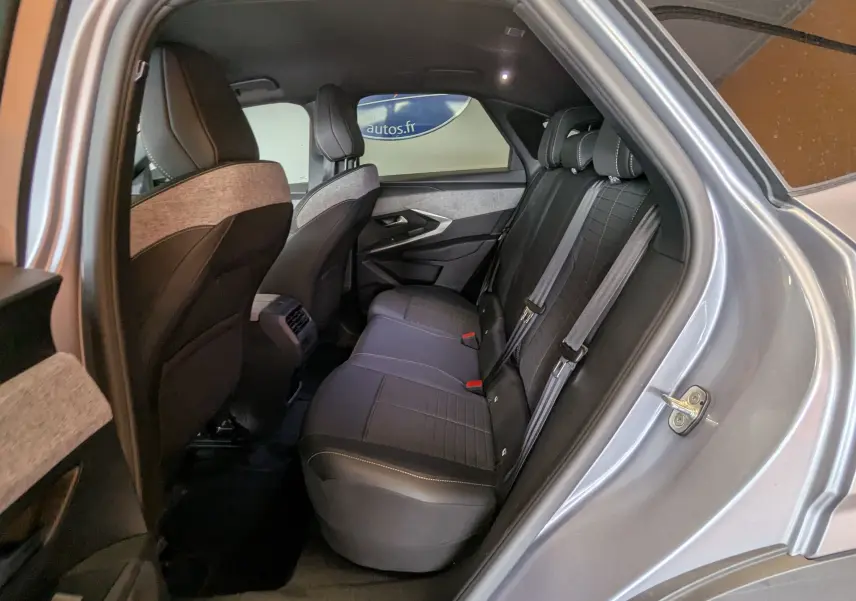 Vue intérieure côté arrière droit du Peugeot 3008 gris 2024, montrant les sièges arrière en tissu et cuir avec ceinture de sécurité.