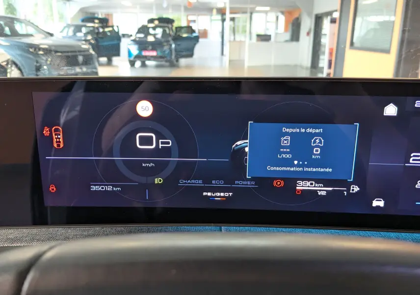 Affichage numérique du tableau de bord du Peugeot 3008 hybride 2024, montrant la vitesse à 0 km/h et l'autonomie à 390 km.