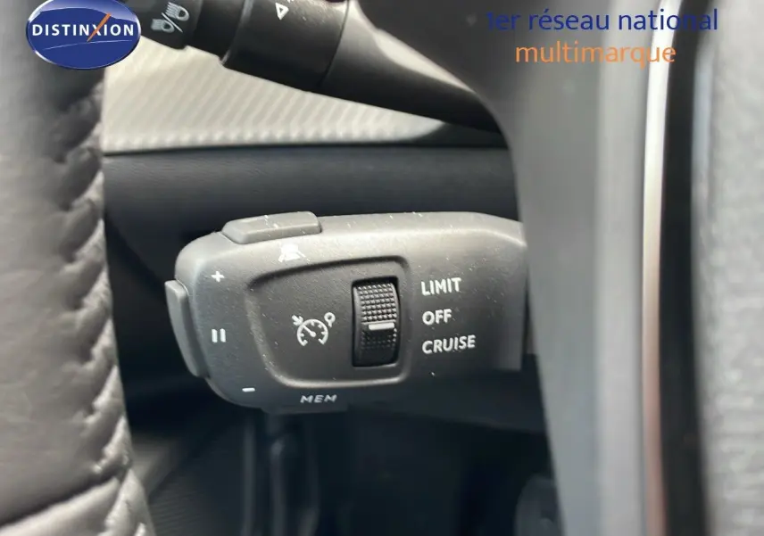 Gros plan sur la commande de régulateur de vitesse du Peugeot 2008 noir Perla Metal, côté gauche du volant.