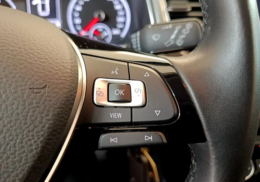 Gros plan sur les commandes multifonctions du volant cuir côté gauche du Volkswagen T-Roc gris foncé 2021.