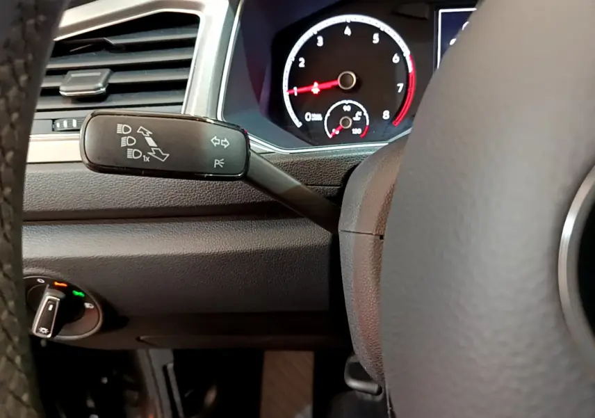 Gros plan sur la manette de clignotants et le tableau de bord noir du Volkswagen T-Roc 1.0 TSI 110 LOUNGE BUSINESS.