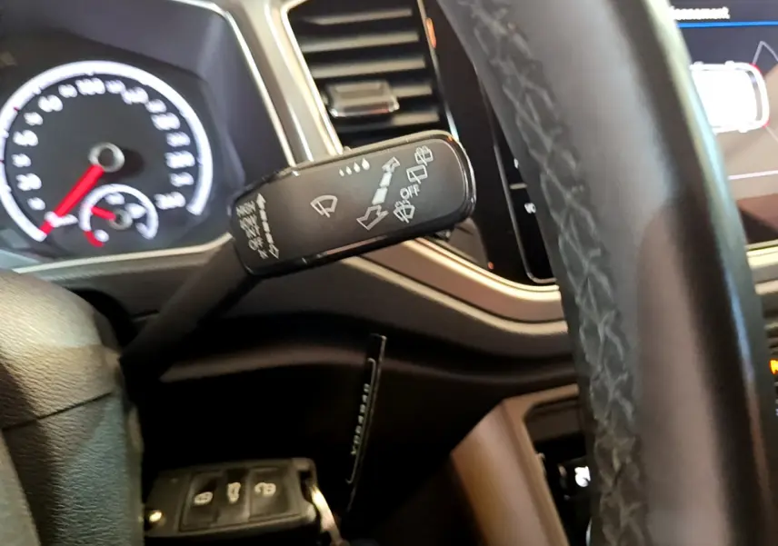 Gros plan sur la manette d'essuie-glace côté gauche du tableau de bord d'un Volkswagen T-Roc 2021 gris foncé.