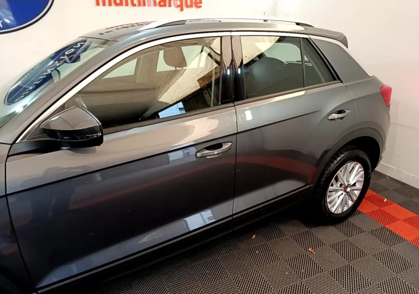 Profil côté gauche du Volkswagen T-Roc gris foncé 2021, mettant en valeur la carrosserie lisse et les jantes alliage.